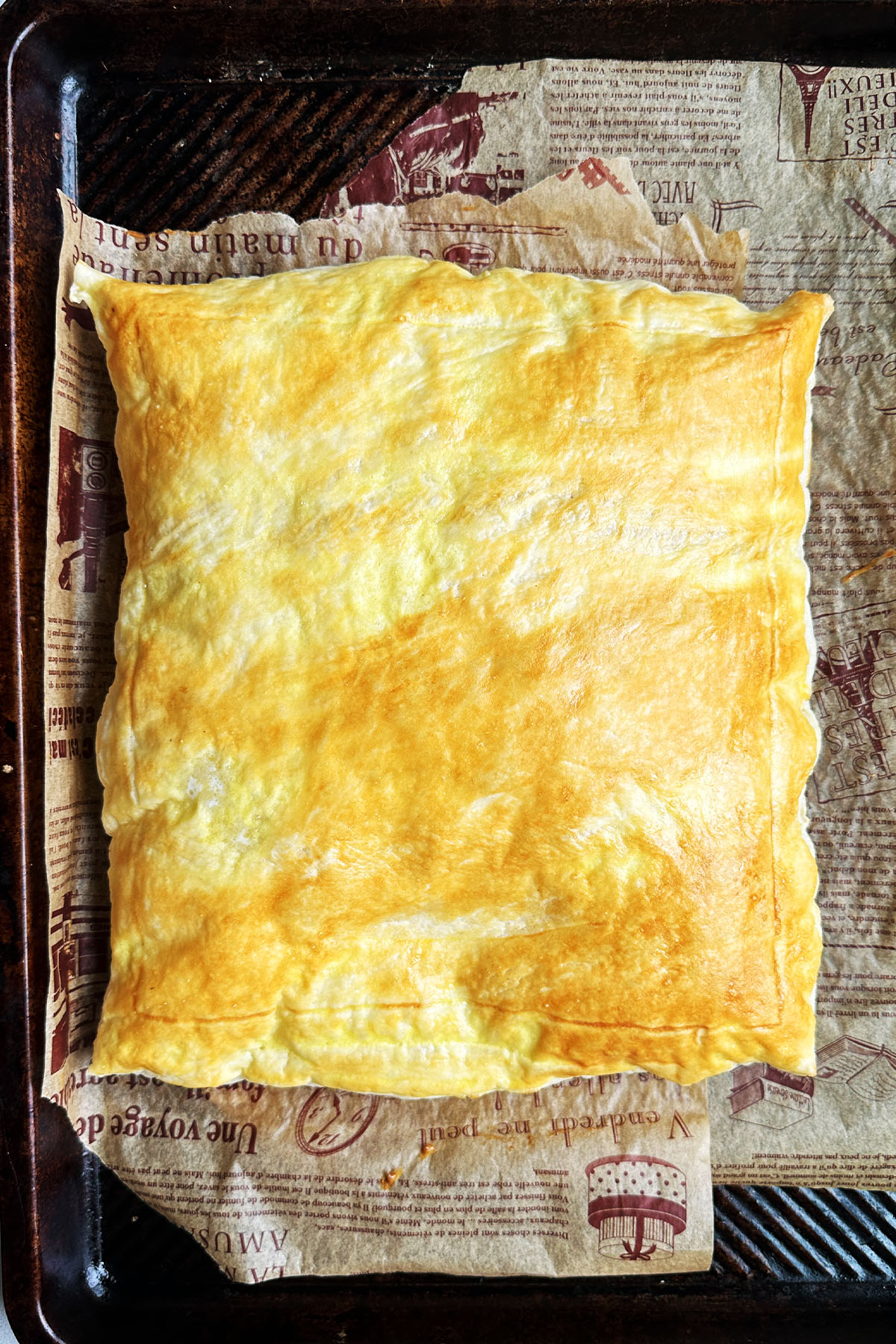 A baked sheet of puff pastry on a baking sheet.