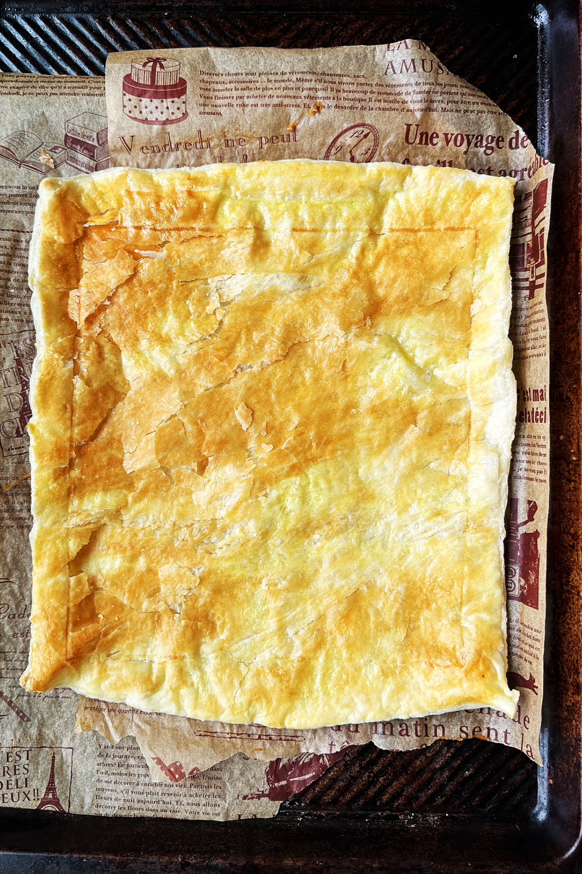 A baked sheet of puff pastry on a baking sheet.