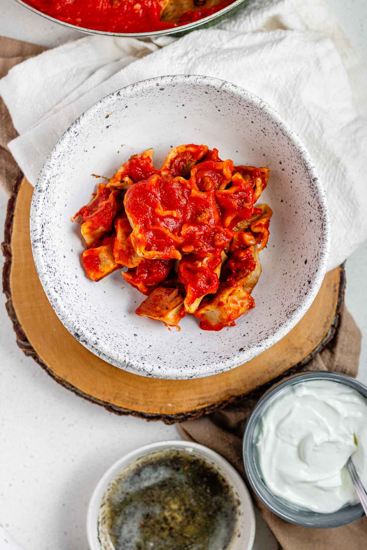 A bowl of dumplings in red sauce.