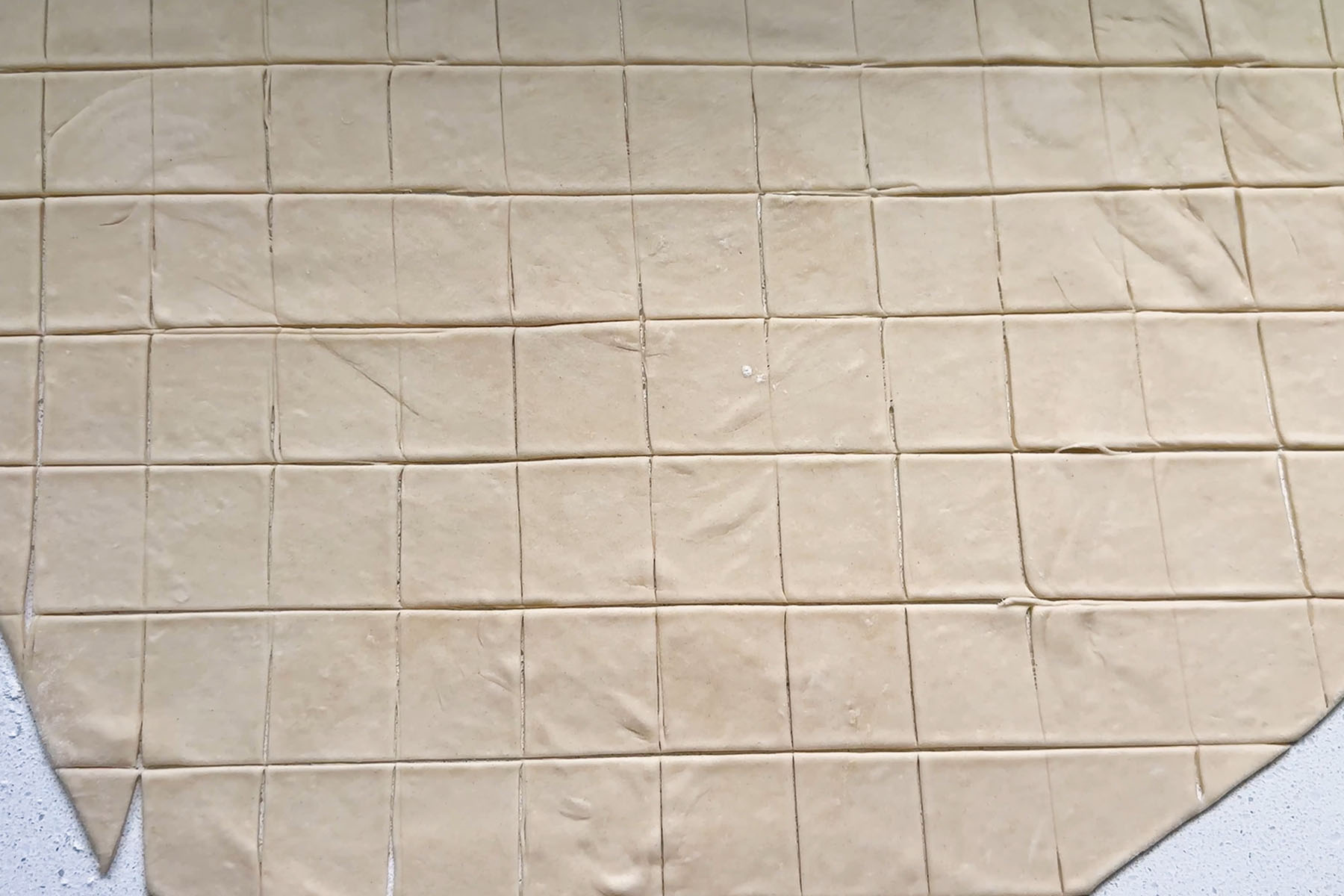 Rolled dough cut into squares.