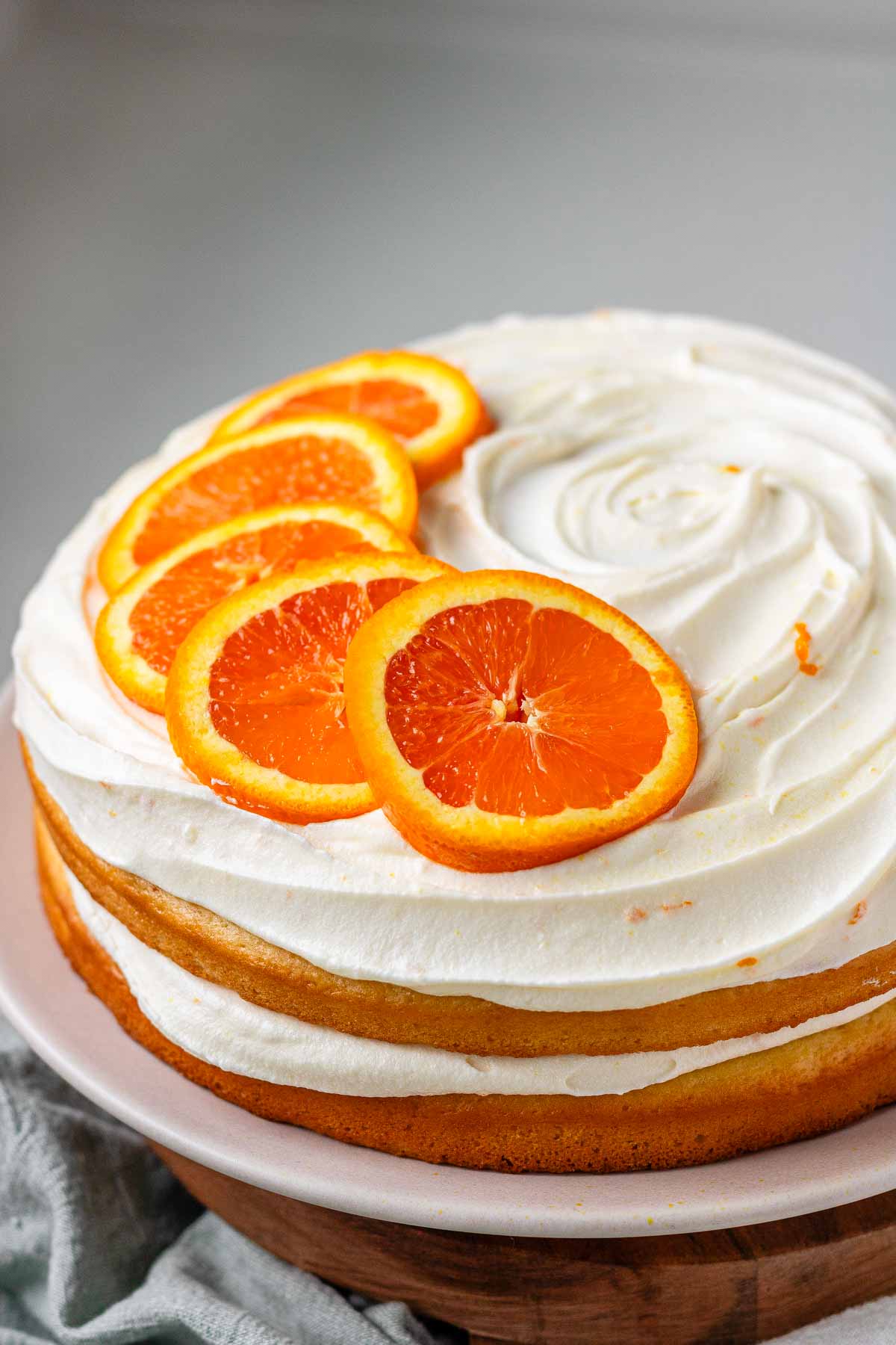 A cake with icing and orange slices on top.