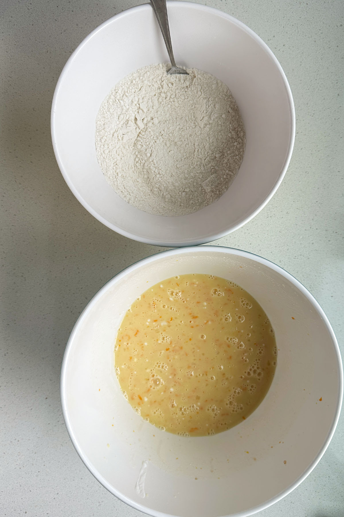 A bowl with wet ingredients and a bowl with dry ingredients for cake batter.