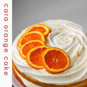 A cake with icing and orange slices on top and the text cara cara orange cake.