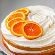 A cake with icing and orange slices on top and the text cara cara orange cake.