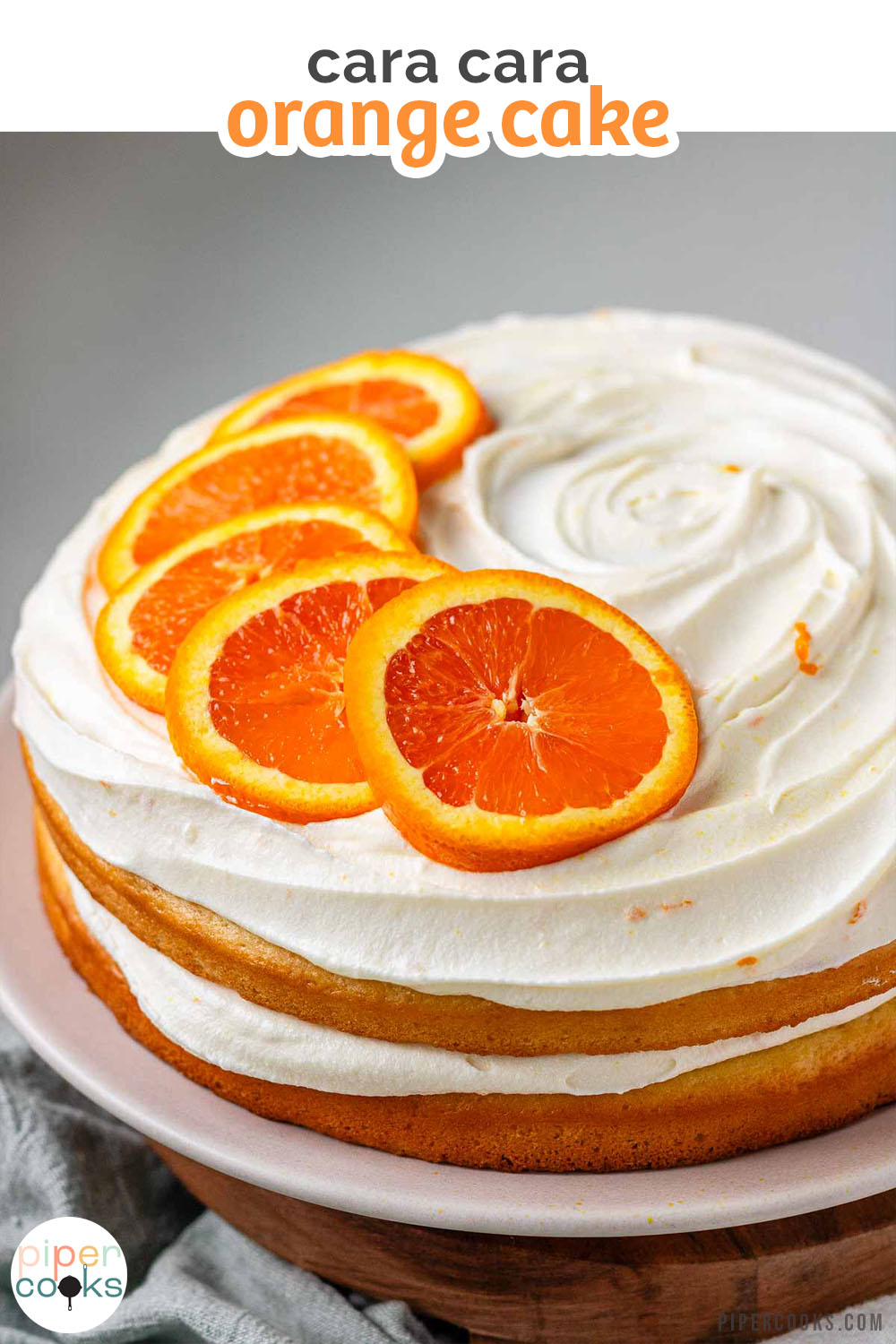 A cake with icing and orange slices on top and the text cara cara orange cake.