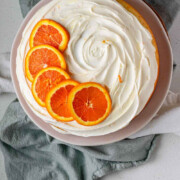 A cake with icing and orange slices on top and the text cara cara orange cake.