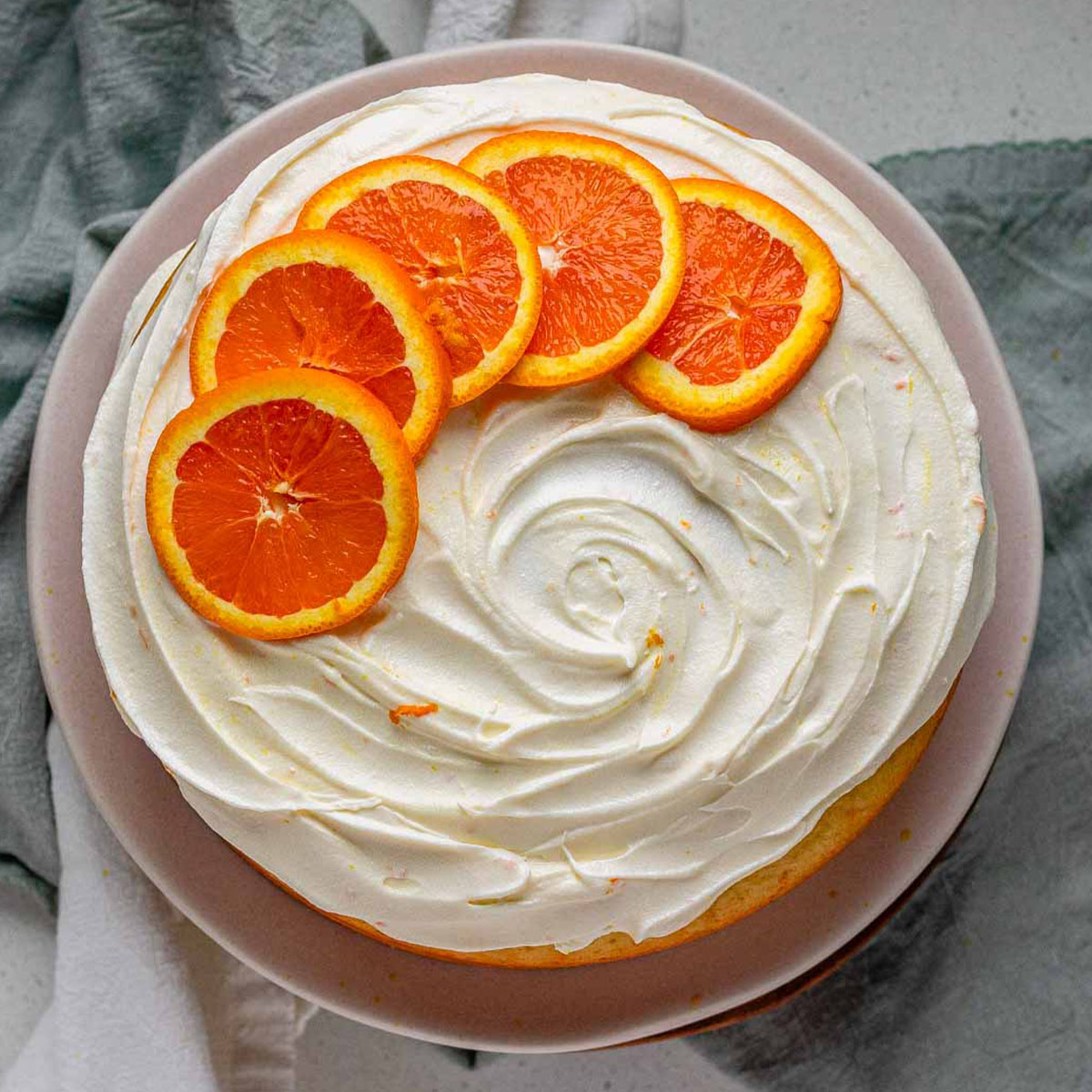 A cake with icing and orange slices on top.