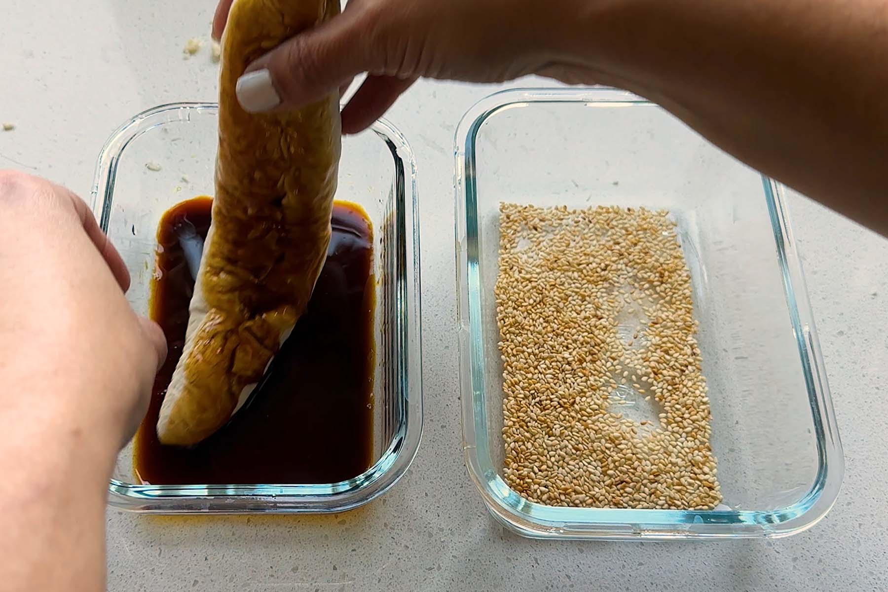 A cylinder of dough is dipped into molasses.