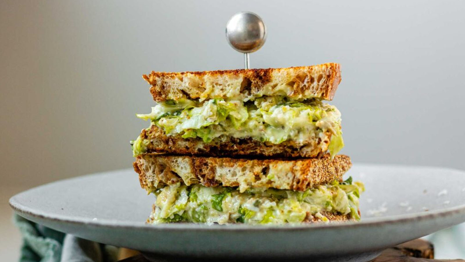 A stacked, halved sandwich with creamy chopped romaine lettuce.