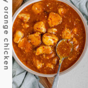 Cubed chicken in orange sauce in a bowl.