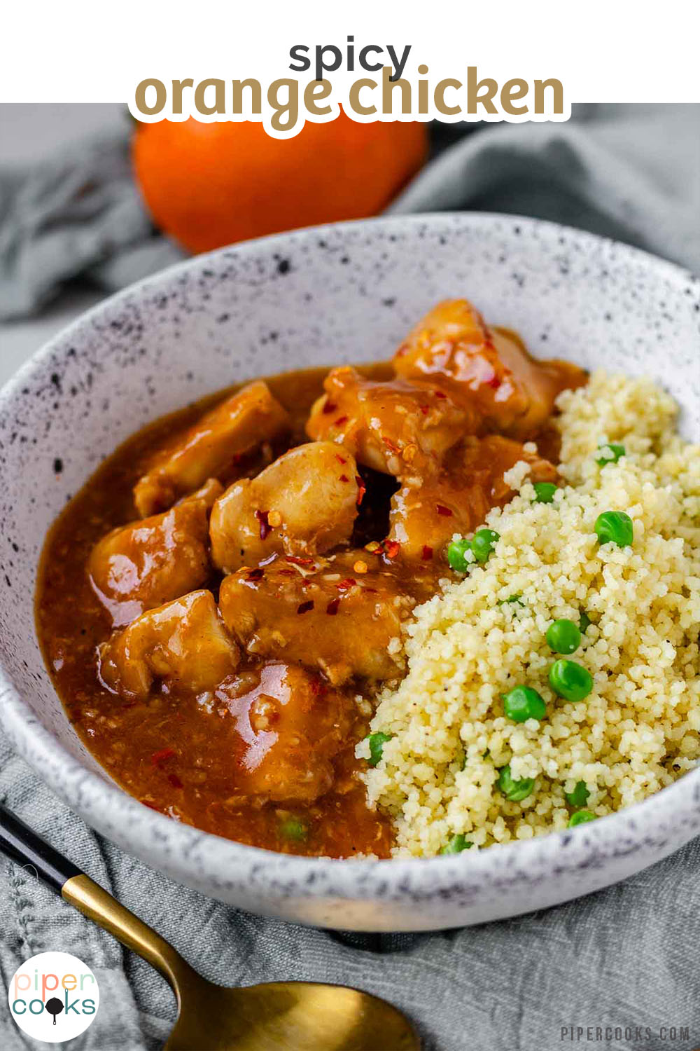 Cubed chicken in orange sauce in a bowl with couscous.