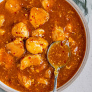 Cubed chicken in orange sauce in a bowl.