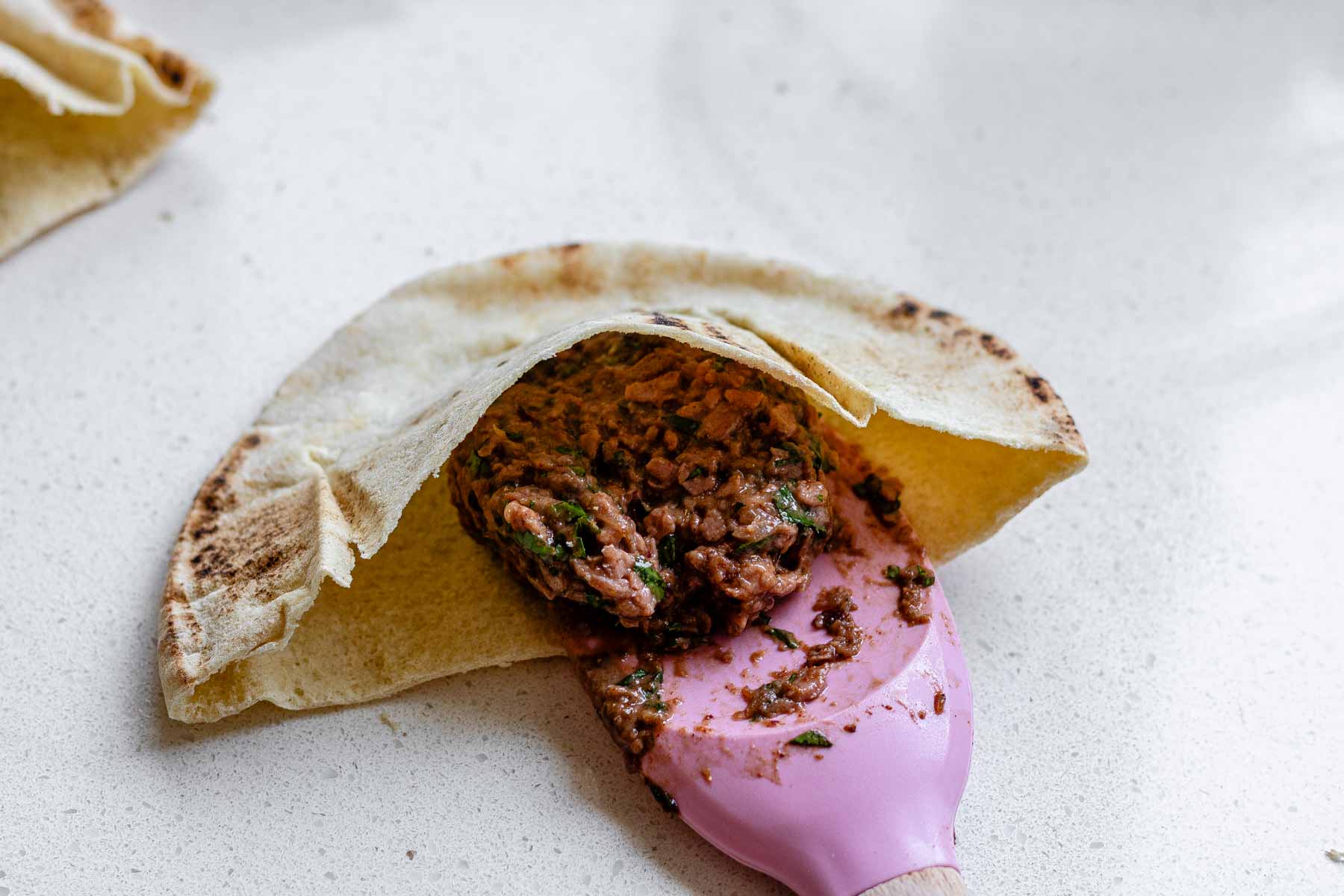 Half a pita stuffed with herb-filled meat.