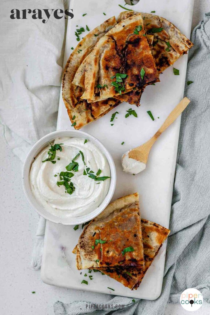 Meat-filled fried pitas with the text arayes.