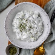 Cucumber yogurt salad in a bowl topped with dried mint.