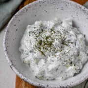 Cucumber yogurt salad in a bowl topped with dried mint.