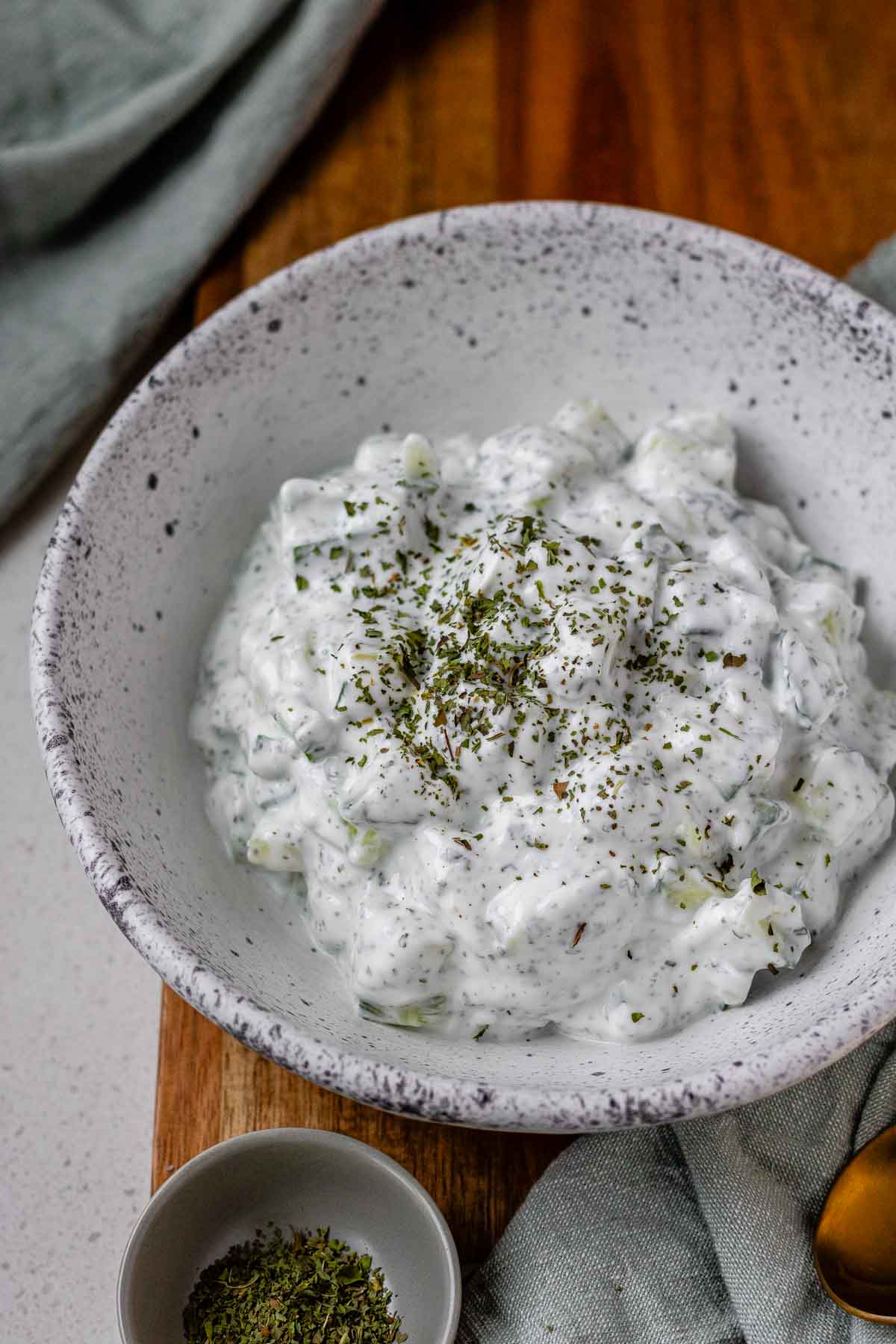 Cucumber yogurt salad in a bowl topped with dried mint.