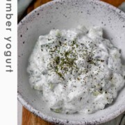 Cucumber yogurt salad in a bowl topped with dried mint with the text cucumber yogurt.