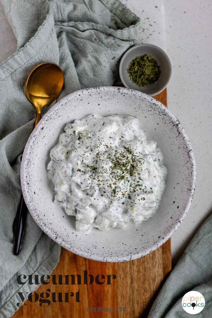 Cucumber yogurt salad in a bowl topped with dried mint with the text cucumber yogurt.