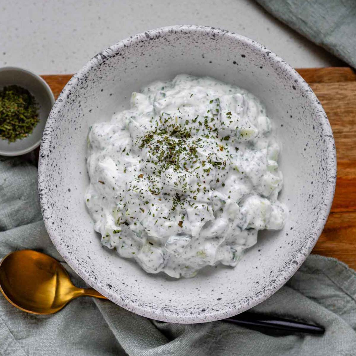 Cucumber yogurt salad in a bowl topped with dried mint.