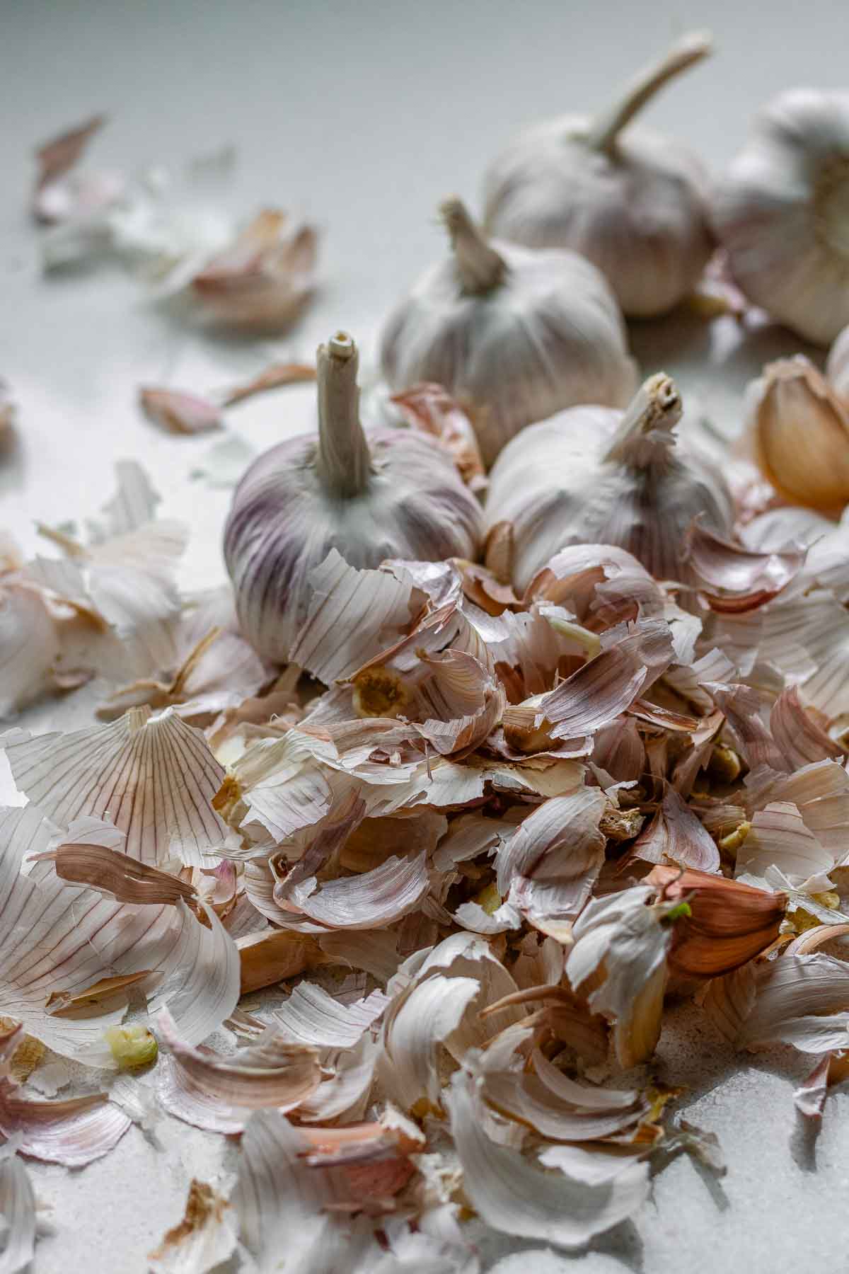 Heads of garlic surrounded by garlic peels.