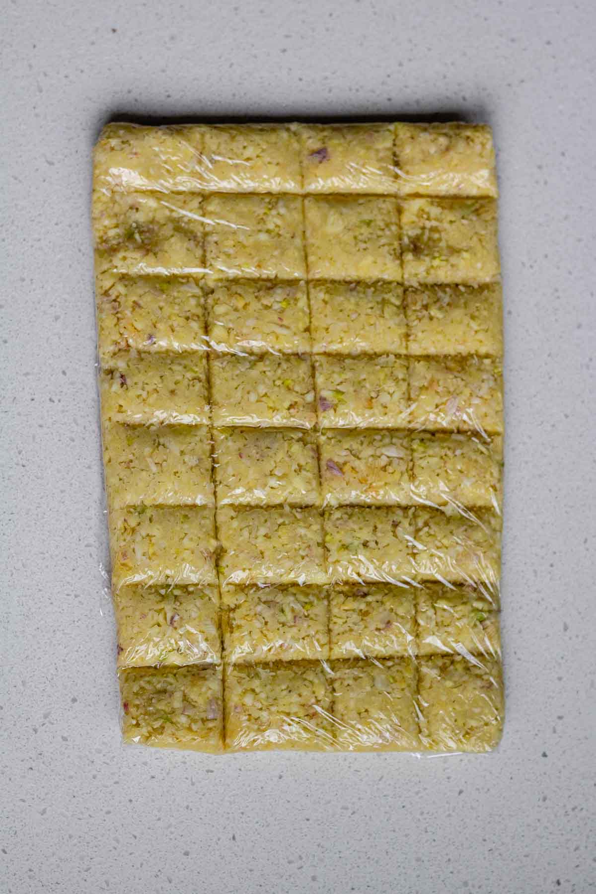 Minced garlic formed into a flat rectangle and sectioned into squares.