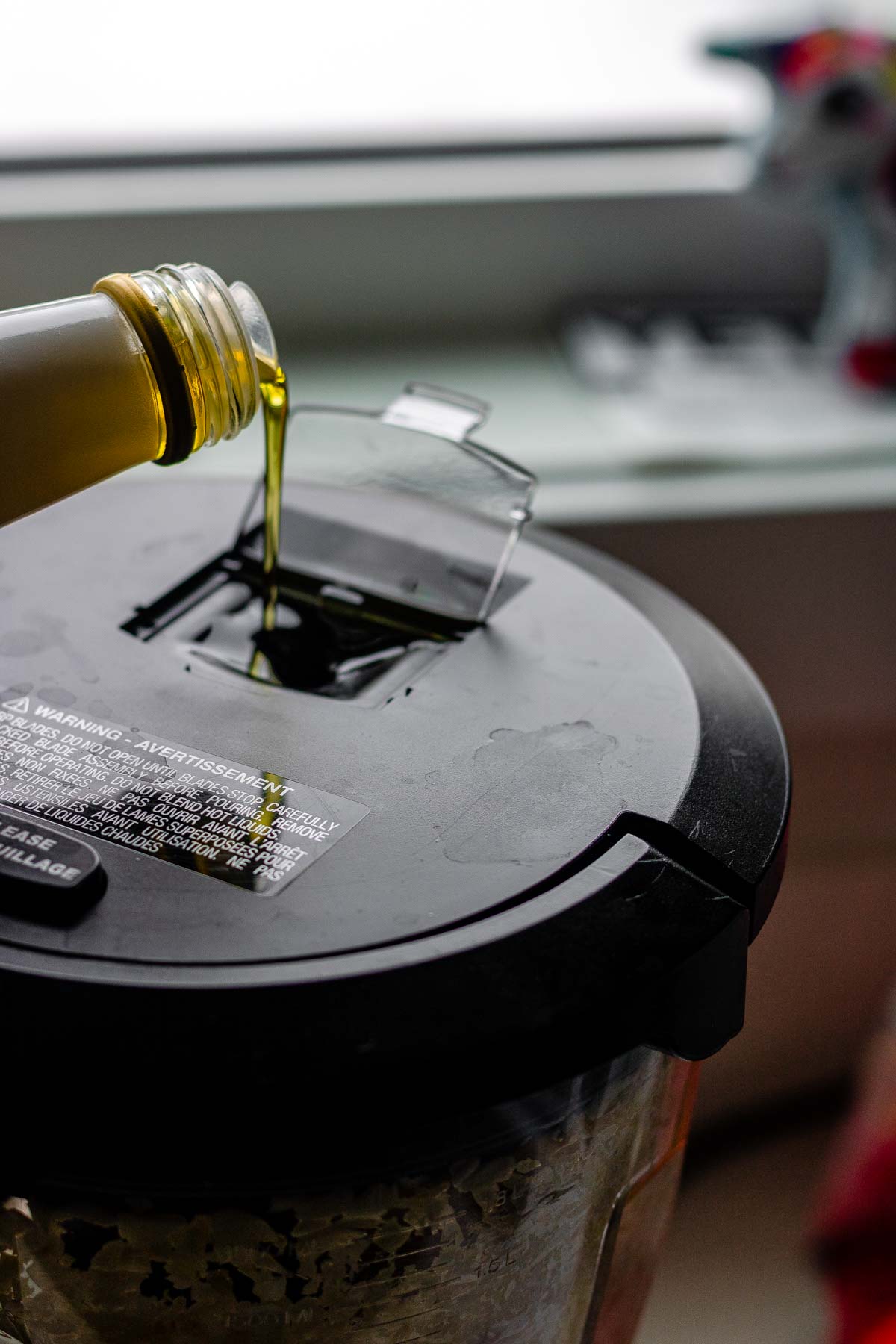 Oil drizzling into a food processor.