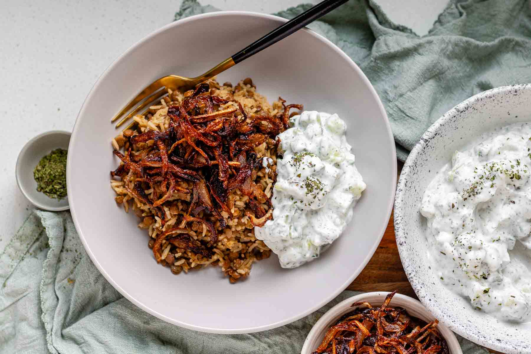 A bowl of rice and lentils, topped with crispy onions.