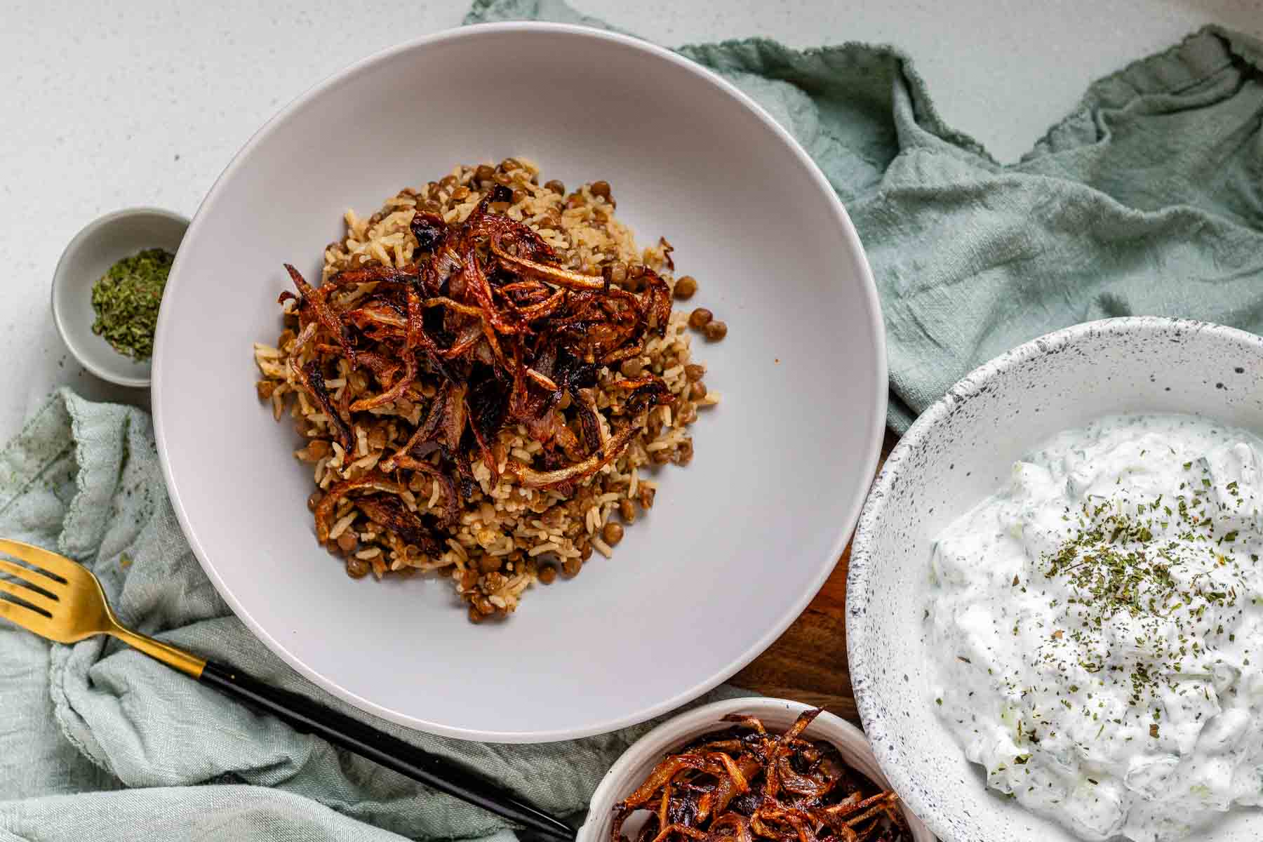 A bowl of rice and lentils, topped with crispy onions.