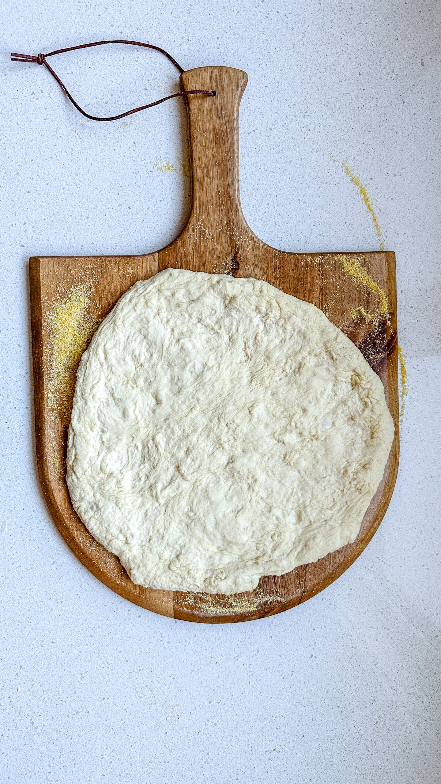 Pizza dough on a pizza peel.