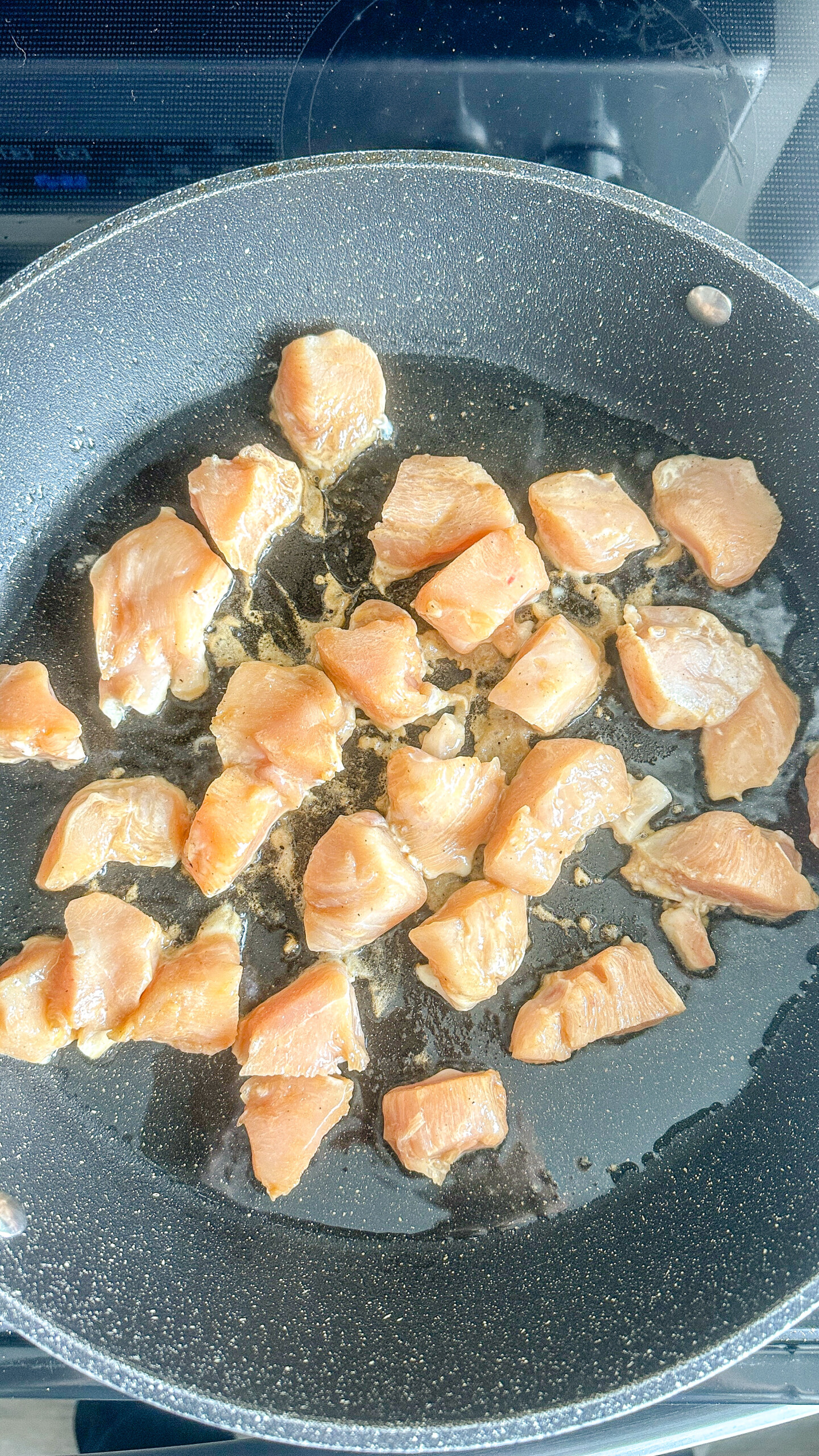 Cubed chicken in a skillet.