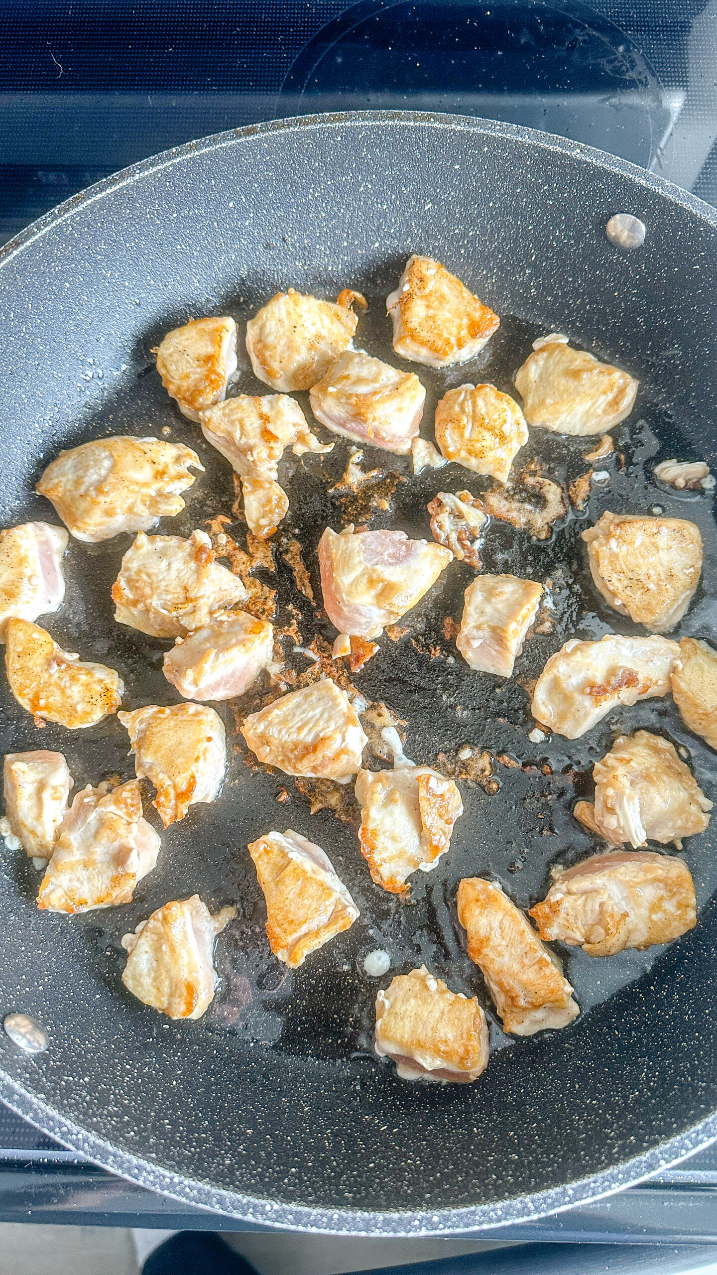 Cubed chicken in a skillet.