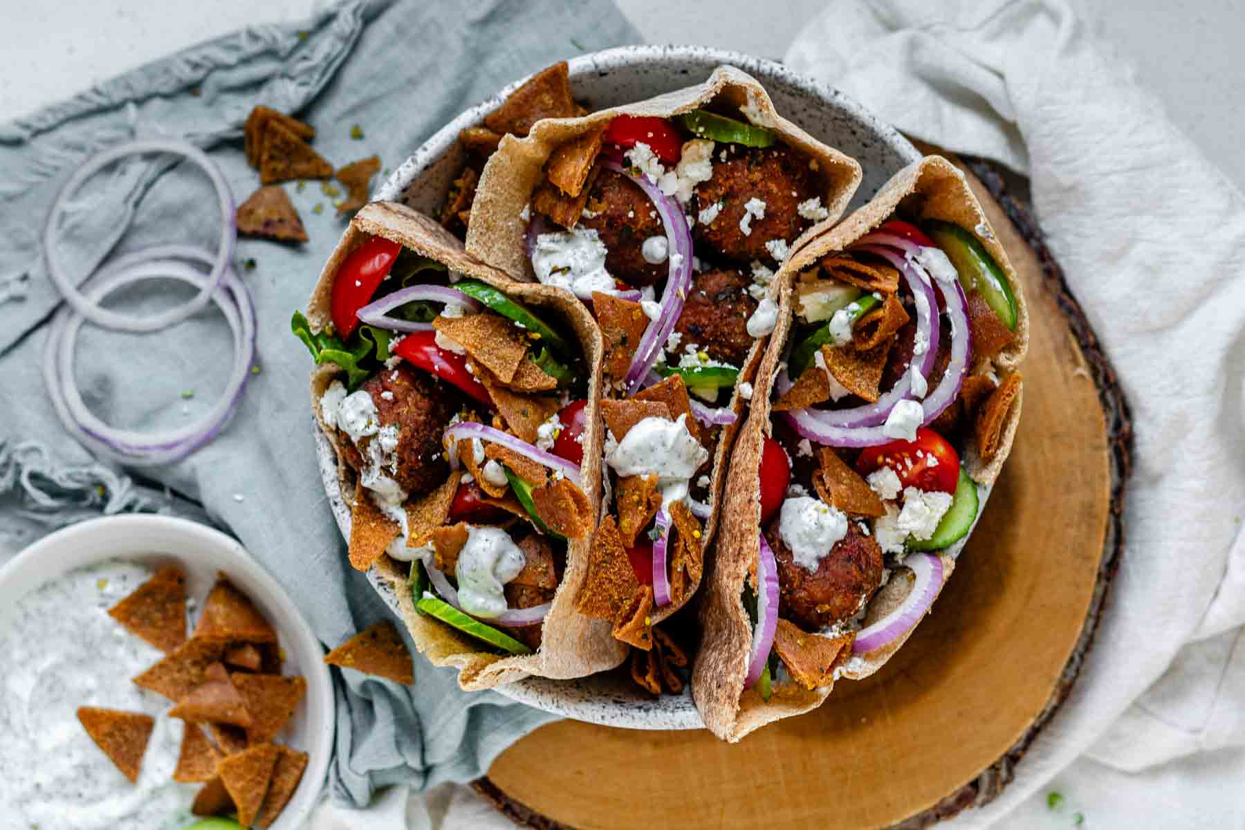 Pita stuffed with meatballs, tomato, cucumber, onion, tzatziki, and crispy pita bits.