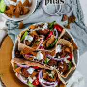 Pita stuffed with meatballs, tomato, cucumber, onion, tzatziki, and crispy pita bits with the text za'atar meatball pitas.