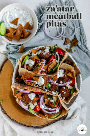 Pita stuffed with meatballs, tomato, cucumber, onion, tzatziki, and crispy pita bits with the text za'atar meatball pitas.