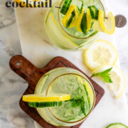 A cocktail garnished with lemon and cucumber slices and fresh mint with the text cucumber mint vodka cocktail.