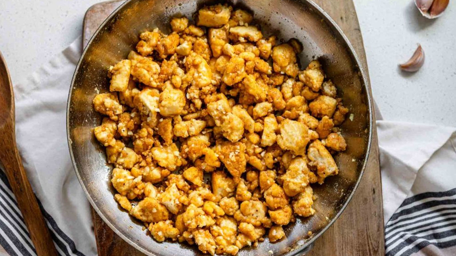 Tofu in a skillet in a light garlic butter sauce.