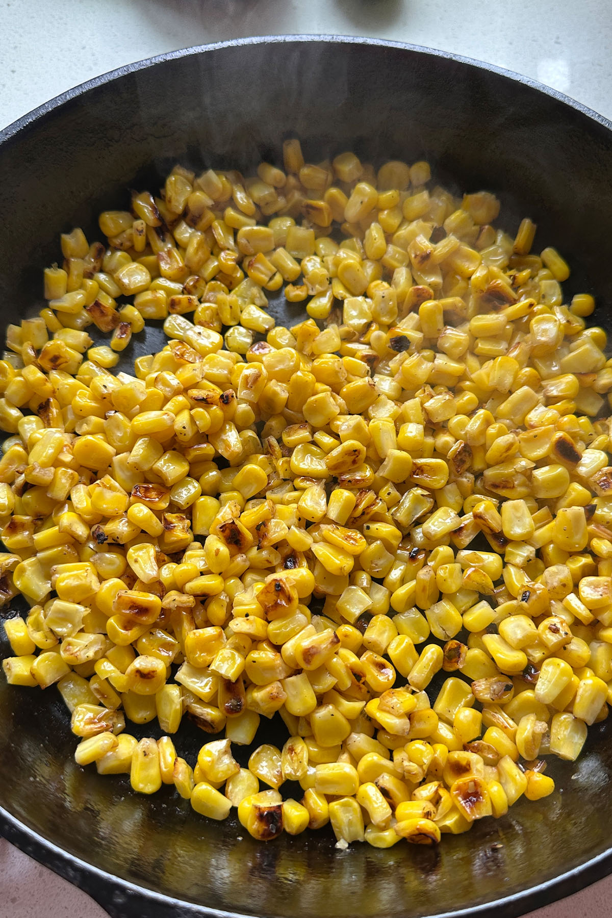 Charred corn in a cast iron skillet.