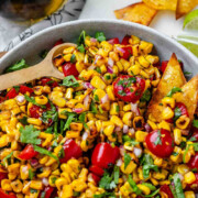 A corn and tomato salsa in a bowl with the text charred corn salsa.