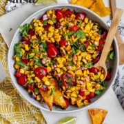 A corn and tomato salsa in a bowl with the text charred corn salsa.