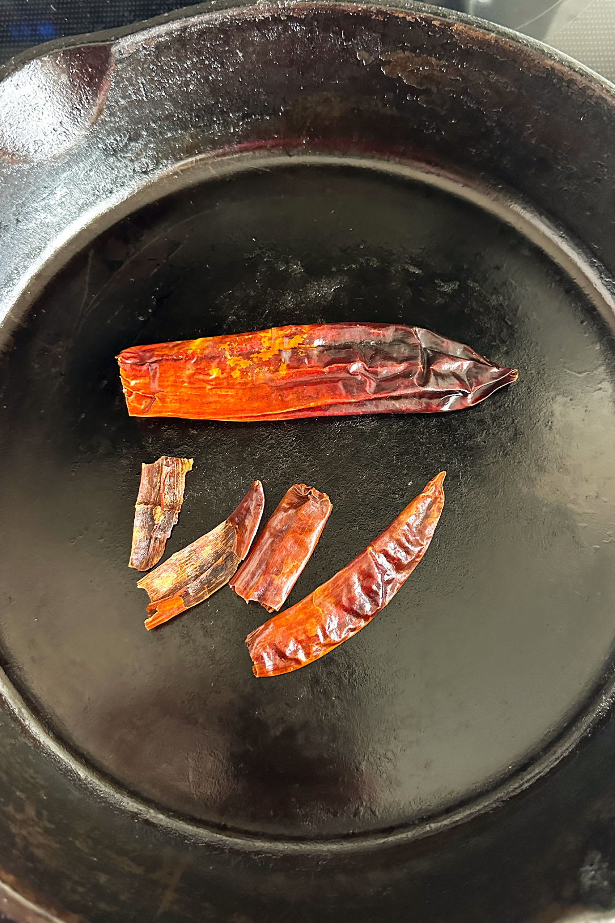 Dried chilies in a cast iron skillet.