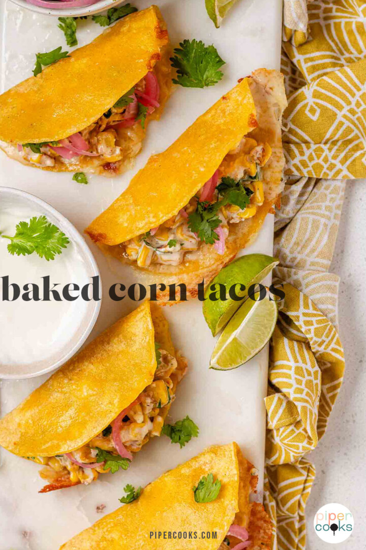 Cheesy crispy corn tacos on a white platter with garlic lime crema and pickled onions and lime wedges with the text baked corn tacos.