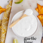 A white sauce in a bowl with the text garlic lime crema.