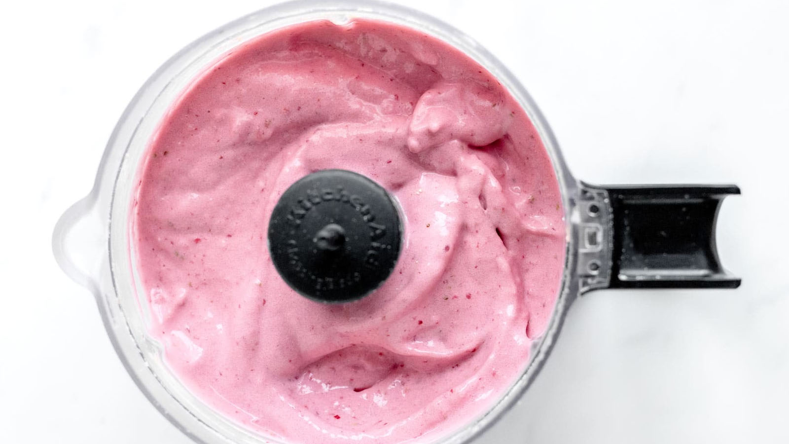Creamy strawberry cottage cheese dessert in a food processor.