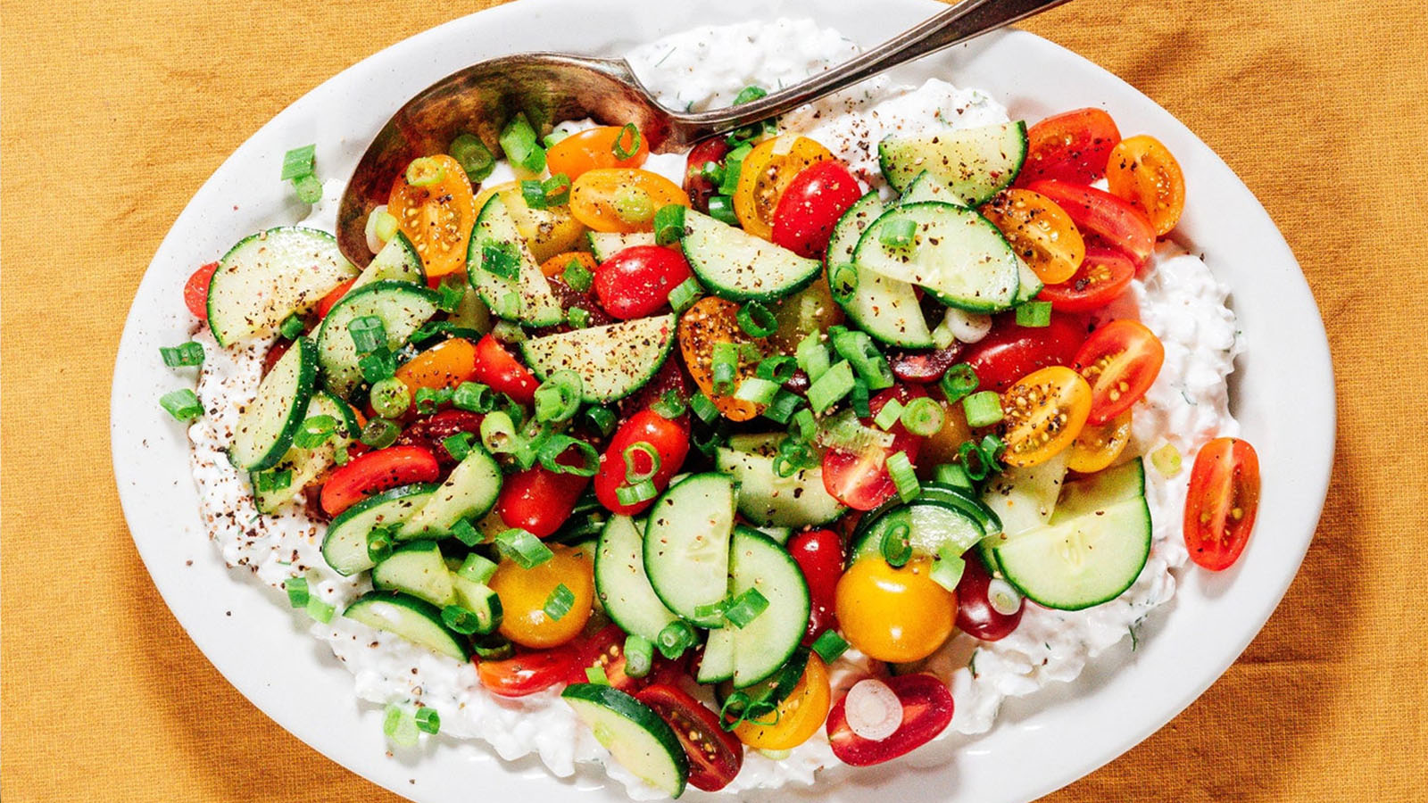 Cottage cheese salad with tomatoes, cucumber, green onion, and fresh herbs.
