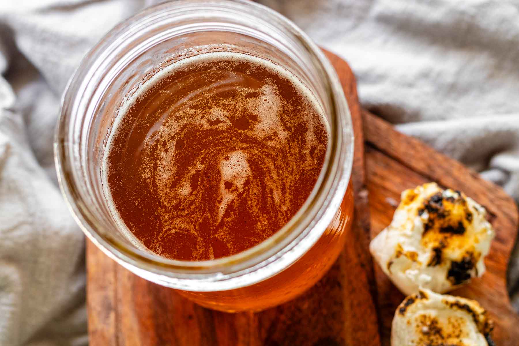 Toasted marshmallow syrup in a glass jar with toasted marshmallows.