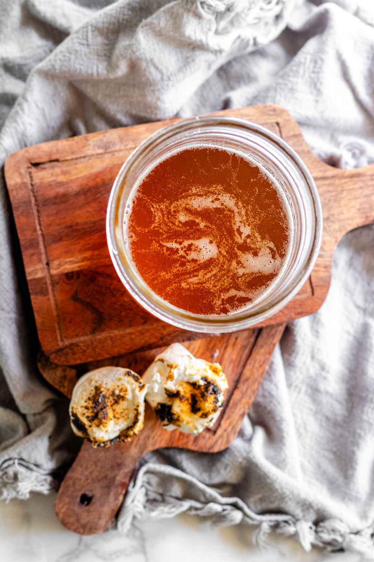 Toasted marshmallow syrup in a glass jar with toasted marshmallows.