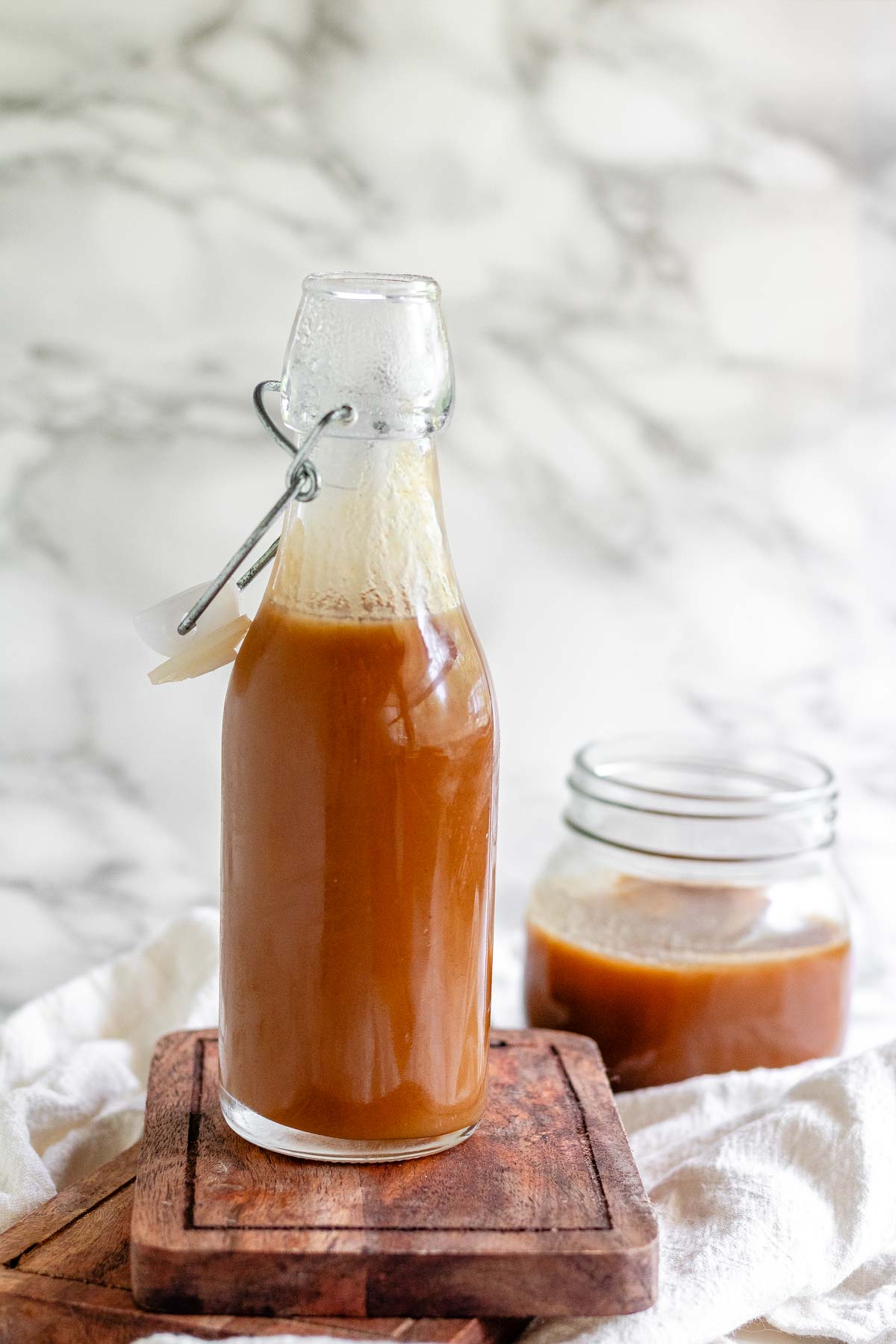 Homemade peanut butter syrup in a glass jar.