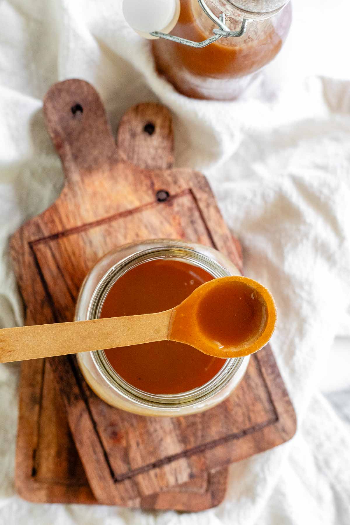 Homemade peanut butter syrup in a glass jar.