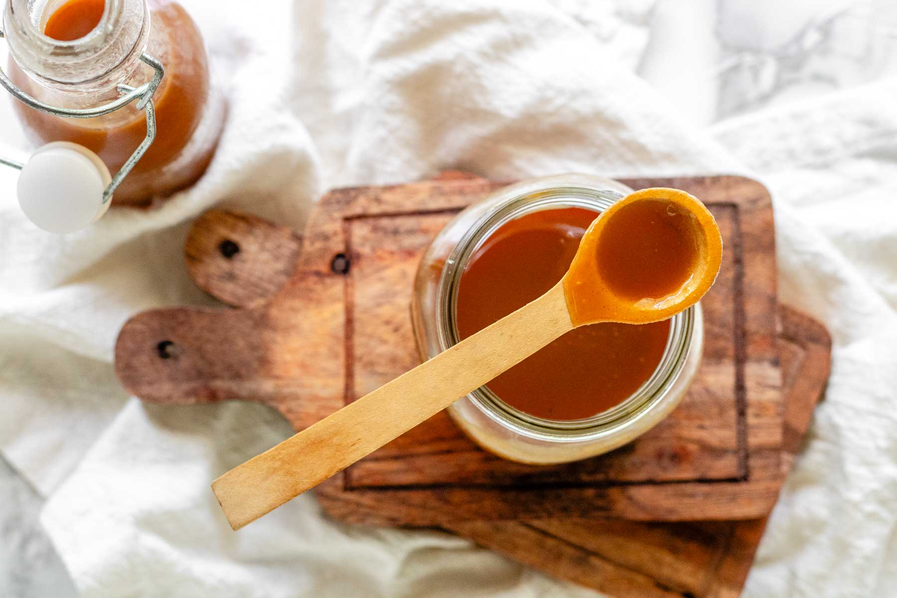 Homemade peanut butter syrup in a glass jar.